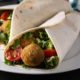 Pan pita, tomate, lechuga, cebolla, falafel y salsa tzatziki
